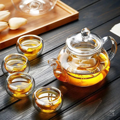 Théière Clara présentée avec quatre tasses en verre sur un plateau en bois